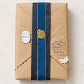 Table Tales surprise book wrapped in kraft paper with a blue ribbon and gold wax seal